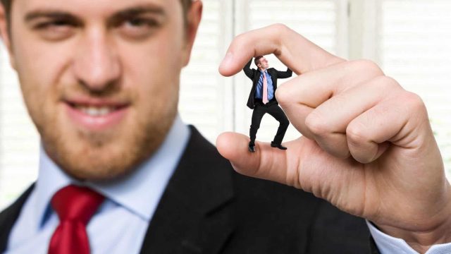 Big Businessman Pressing Little Bussisman w Fingers1 | موسوعة الشرق الأوسط