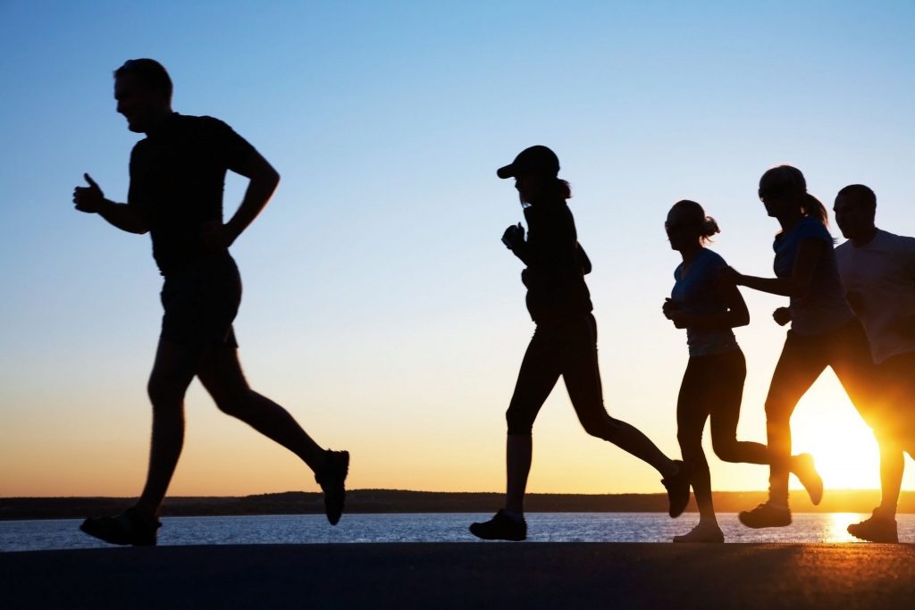 group of young people runs at the beach on beautiful summer sunset | موسوعة الشرق الأوسط